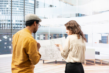 Real estate broker and entrepreneur meeting on an office hunt inside urban building, touring potential relocation property and discussing investment opportunity. Rental agreement.