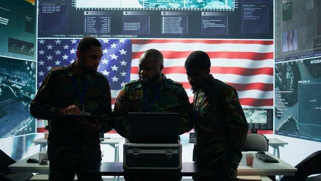 Military officer in a high tech control center engages in cybersecurity operations, protecting classified data from threats and managing digital warfare strategies to maintain state secrets. Camera B.