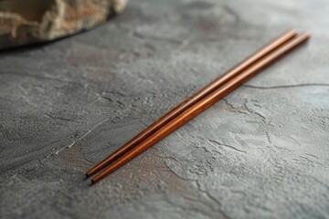 A pair of chopsticks placed on a table, often used for eating Asian-style cuisine