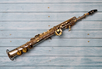 Soprano saxophone on beautiful blue wooden background.