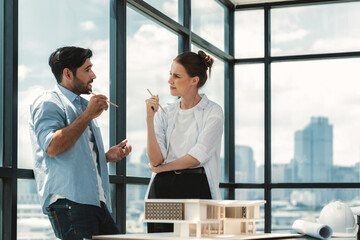 Professional architect engineer team discussing about house construction. Expert businesspeople sharing and brainstorming idea about house design. Working together. Skyscraper. Tracery.