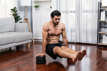 Athletic body and active sporty man lifting himself for effective targeting muscle bodybuilding gain at gaiety home as concept of healthy fit body home workout. Bodybuilder at home gym lifestyle.