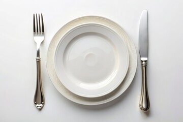 Elegant table setting featuring a pristine white plate, paired with a stainless steel knife and fork, arranged on a crisp white background.