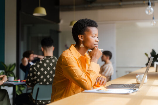 Businesswoman Working On Laptop In Modern Workplace