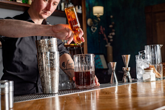 Bartender prepares cocktail at the bar counter