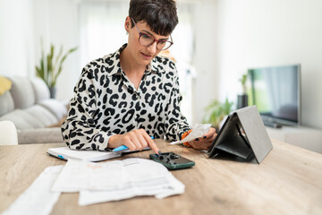 Focused accountant managing monthly budget using calculator