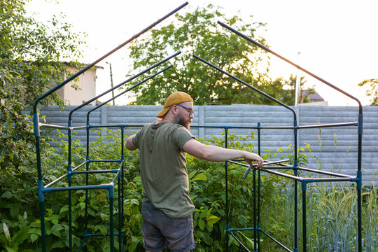 man in the middle of a greenhouse frame