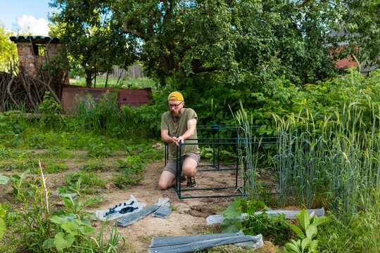 a man at the initial stage of collecting a greenhouse