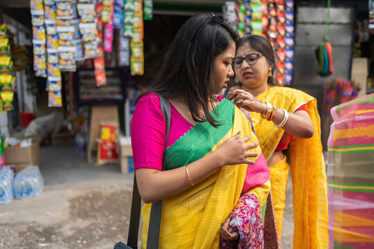 Mother fixing the apparel of her daughter at outdoors