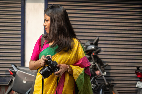 Young Indian lady holding camera in a street of small town