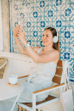 Woman making self portrait against a tiled wall in Portuguese ou