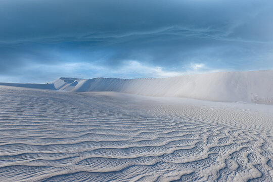 Thunderstorm clouds over white sand dunes