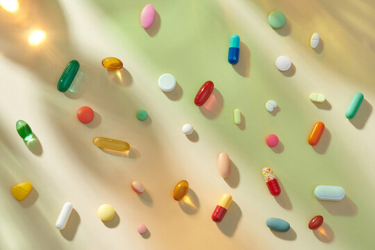 Assorted Colorful Pills and Capsules on Gradient Background
