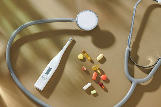 Medical Equipment with Pills and Stethoscope on Brown Background