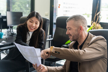 Business Colleagues Smiling And Checking Documents.

