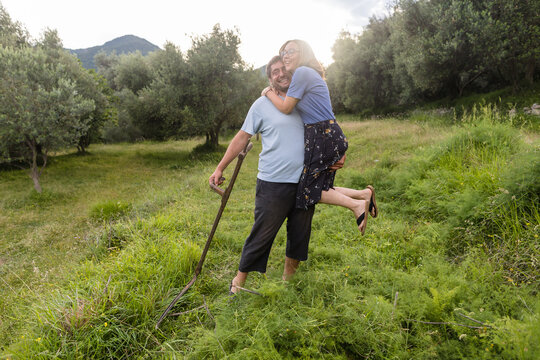 Farmer holds his wife in his hands in the field