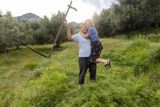 Farmer holds his wife in his hands in the field
