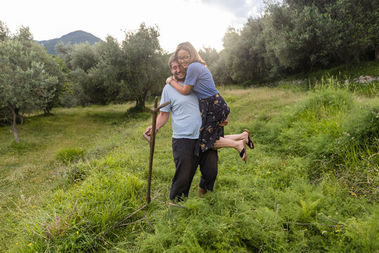 Farmer holds his wife in his hands in the field