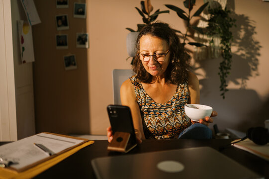 middle aged office worker at home eating lunch at desk