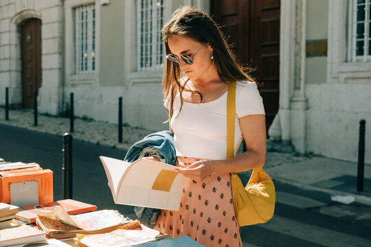 Woman looking at a book on flee market in Lisbon