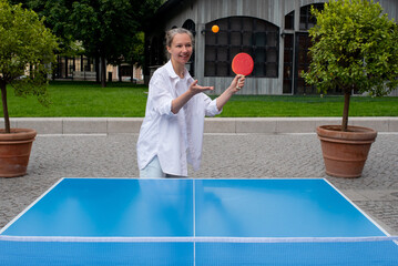 Woman pitchs a ball in table tennis play