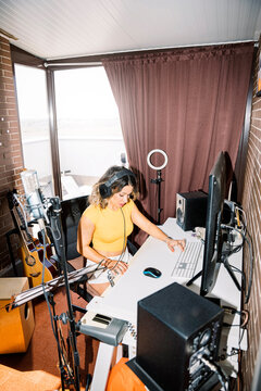Music woman producer At Home Studio Using Keyboard Controller