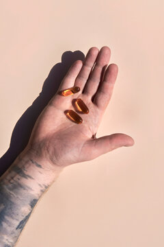 Male hand holding pills in sunlight. Studio shot with copy space