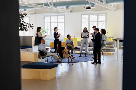 Group of diverse business people applauding a male leader at office