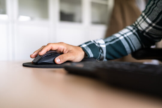 Programmer working from home using mouse and keyboard on desk