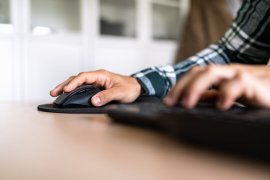 Programmer working from home using mouse and keyboard on desk