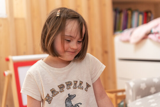 Portrait Of A Girl With Down Syndrome Smiling in Playroom