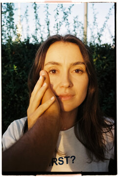 Woman touched on cheek in golden light