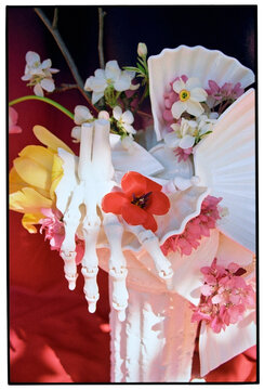 Skeleton Hand Holding Flowers in White Vase