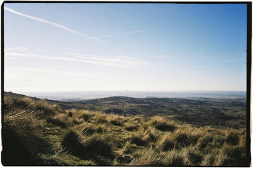 Rolling Hills and a Distant Cityscape Under a Clear Blue Sky