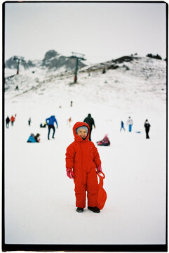 Little boy in Red Snowsuit at Snowy Mountain