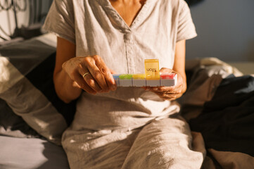 woman taking supplement pill at home in bedroom