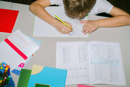 A boy draws in his notebook instead of solving math examples.