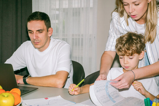 Father, mother and son doing math homework together 