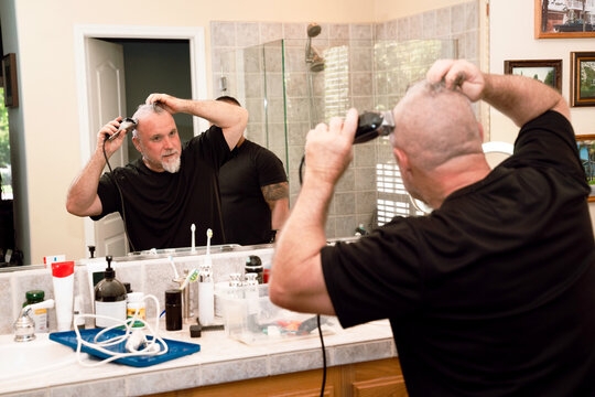 Man Shaving Head in Bathroom Mirror - Powered by Adobe
