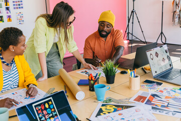 Diverse creative team collaborating on project in modern office