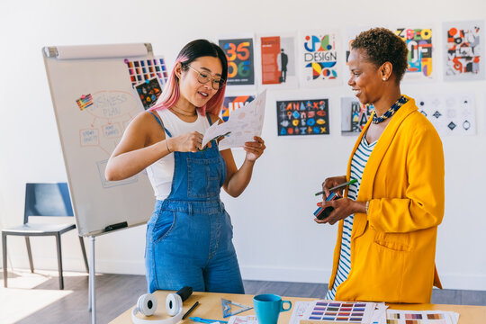 Creative design collaboration between two women in modern workspace - Powered by Adobe