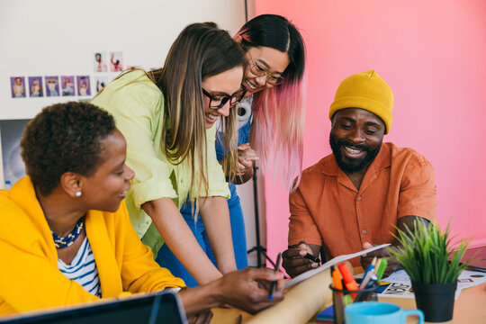 Creative team collaborates on project in bright, colorful workspace