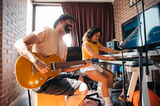Performers playing piano and singing while recording in studio