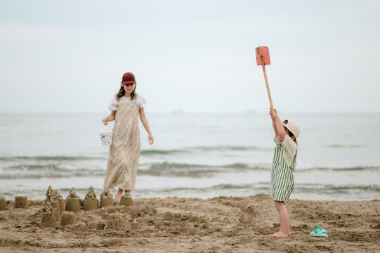 Mom and son building sandcastles on the beach