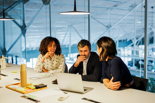Business team having meeting analyzing financial data on laptop
