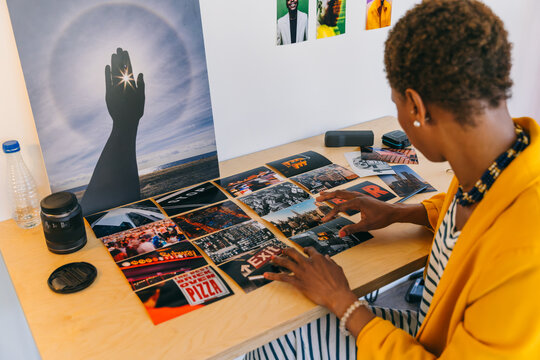 Photographer reviewing prints and artwork at a desk - Powered by Adobe