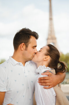 Couple kissing in front of eiffel tower