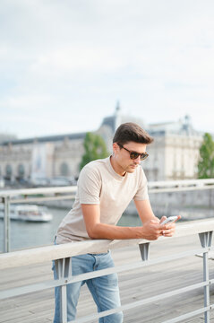 Man using phone on paris bridge