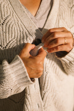 woman getting dressed the morning and buttoning cardigan