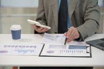 Businessman using calculator with laptop computer, budget and loan documents in office. Company auditor calculating budget with calculator on desk in office. Close up.